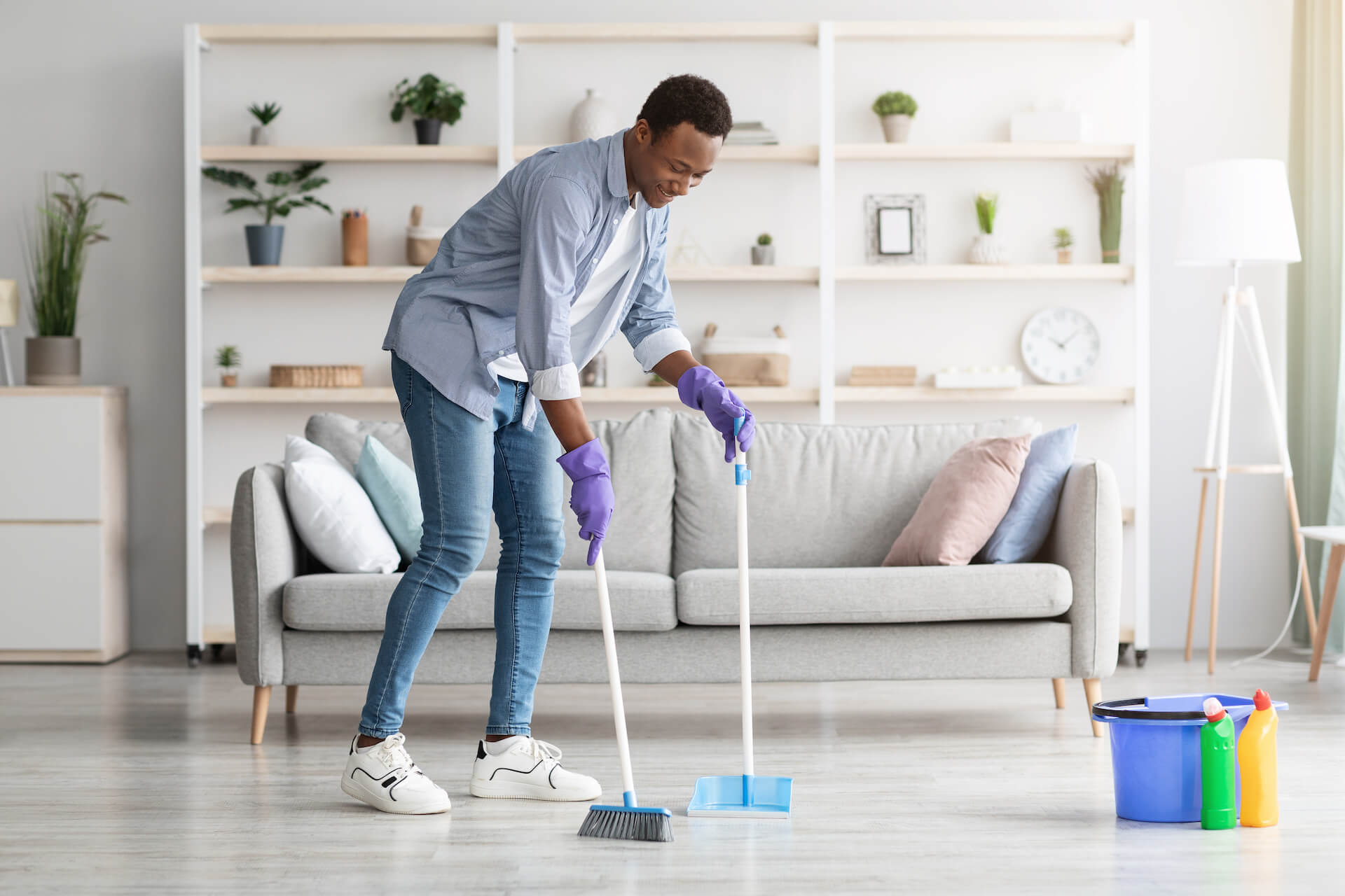 cheerful-black-guy-cleaning-living-room-holding-b-2021-09-04-02-50-46-utc.jpg